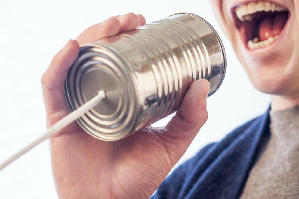 Una persona comunicándose mediante un bote conectado con una cuerda. que gran diferencia de la comunicación como era antes a como es hoy